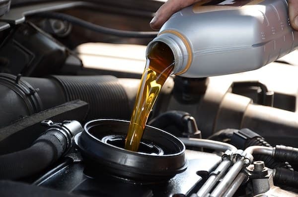 Fresh motor oil being poured into an engine