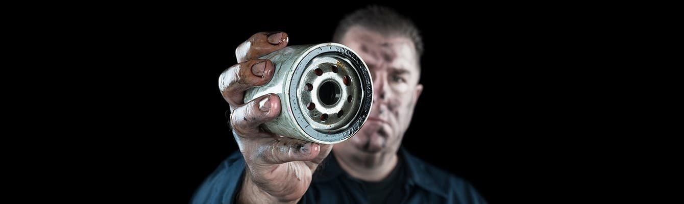 Technician holding a replacement automotive oil filter